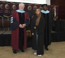 Student robed, then signs Freshmen Book