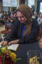 Student robed, then signs Freshmen Book