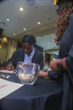 Student robed, then signs Freshmen Book