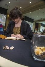 Student robed, then signs Freshmen Book