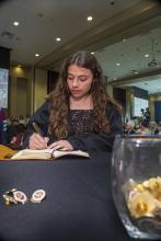 Student robed, then signs Freshmen Book