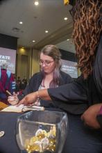 Student robed, then signs Freshmen Book