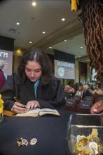 Student robed, then signs Freshmen Book