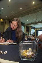 Student robed, then signs Freshmen Book