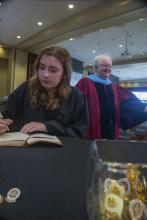 Student robed, then signs Freshmen Book