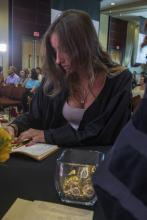 Student robed, then signs Freshmen Book