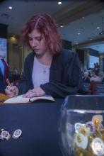 Student robed, then signs Freshmen Book