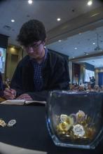 Student robed, then signs Freshmen Book