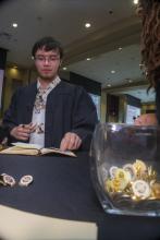 Student robed, then signs Freshmen Book