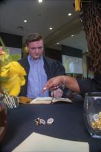 Student robed, then signs Freshmen Book