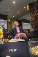 Student robed, then signs Freshmen Book