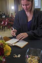 Student robed, then signs Freshmen Book