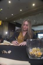 Student robed, then signs Freshmen Book