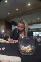 Student robed, then signs Freshmen Book