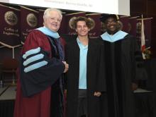 Student robed, then signs Freshmen Book