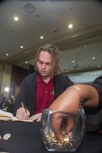 Student robed, then signs Freshmen Book