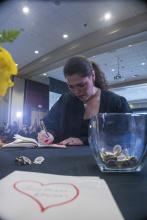 Student robed, then signs Freshmen Book