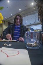 Student robed, then signs Freshmen Book