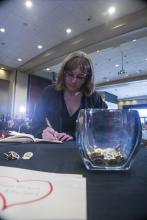 Student robed, then signs Freshmen Book