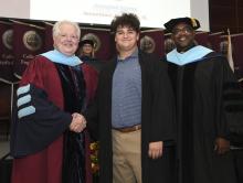 Student robed, then signs Freshmen Book