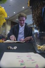 Student robed, then signs Freshmen Book
