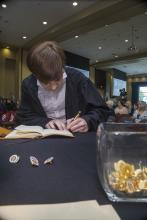 Student robed, then signs Freshmen Book