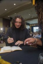 Student robed, then signs Freshmen Book