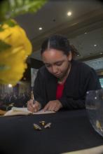 Student robed, then signs Freshmen Book