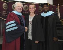 Student robed, then signs Freshmen Book