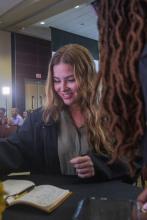 Student robed, then signs Freshmen Book