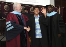 Student robed, then signs Freshmen Book