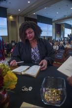 Student robed, then signs Freshmen Book