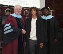 Student robed, then signs Freshmen Book