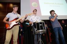 Incoming first-year Devin and Drew Guy with brother Luke, singing and performing the National Anthem