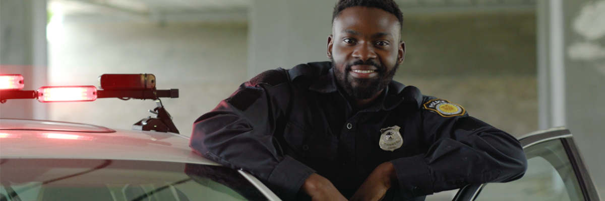 smiling cop standing with car door open